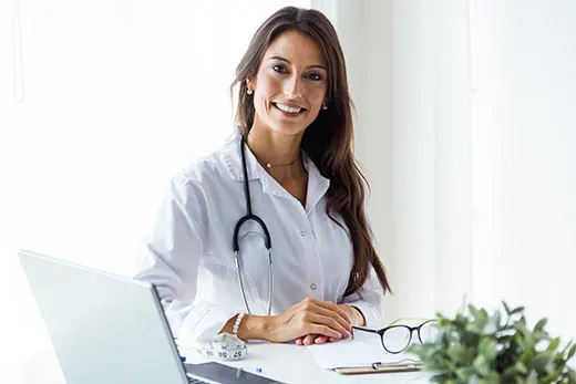 Beautiful young female doctor looking at camera in the office.